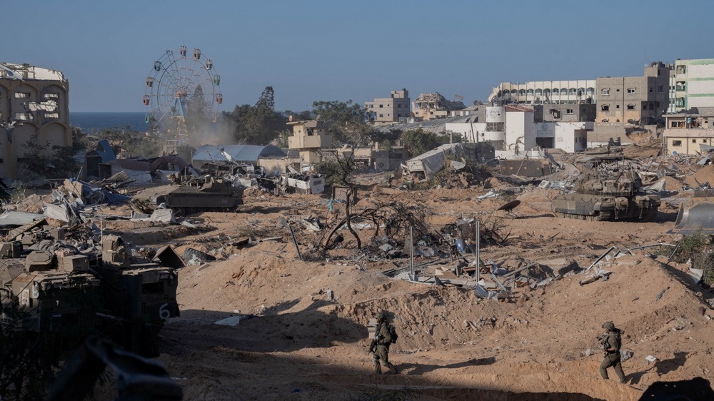 Israeli soldiers walk during an operation as they continue their ground offensive in Gaza