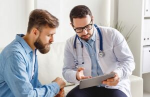 Medical,Practitioner,In,Glasses,Showing,Test,Results,To,Man,And