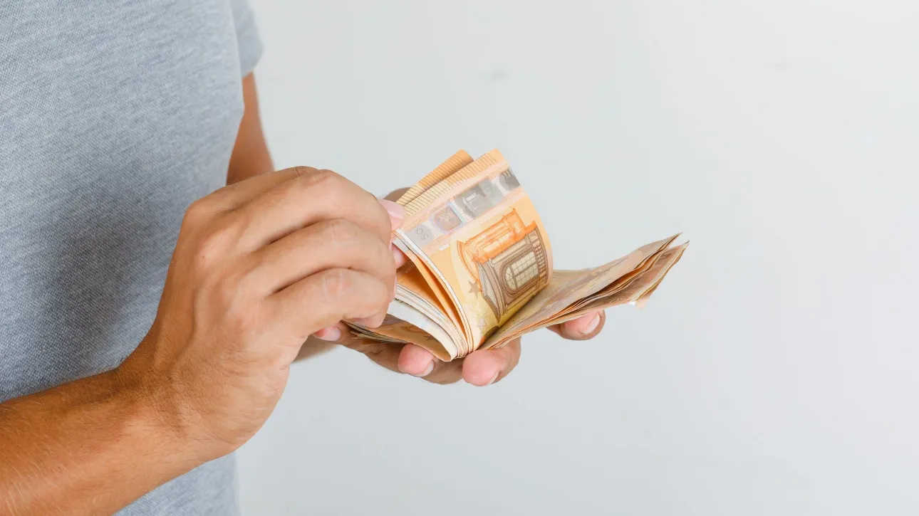 3caf367c young man grey t shirt counting euro banknotes